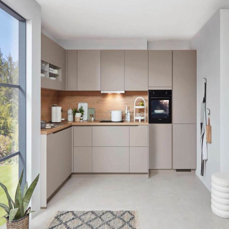 Musterküche in Kaschmir Musterküche in Kaschmir als L-Küche mit Holzrückwand und Backofen im Hochschrank – Küchenstudio Oberhausen